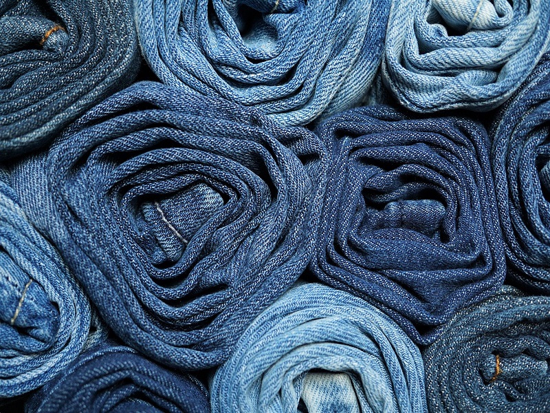 Close-up of blue denim fabric, showing warp and weft pattern thread pattern  and orange stitching. Stitched line, line of stitches Stock Photo - Alamy